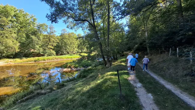 Marcheurs sur un chemin de terre au bord de la Truyère, à l'ombre des arbres